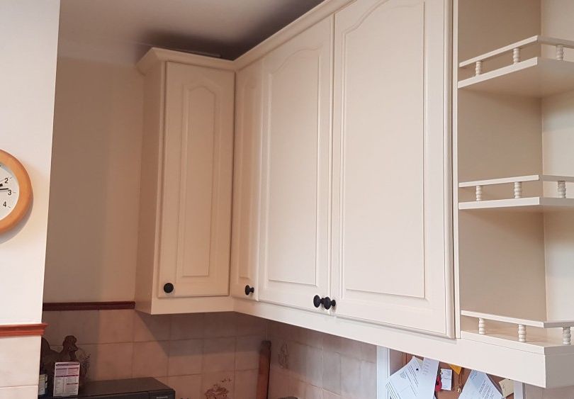 white painted cupboards and clock